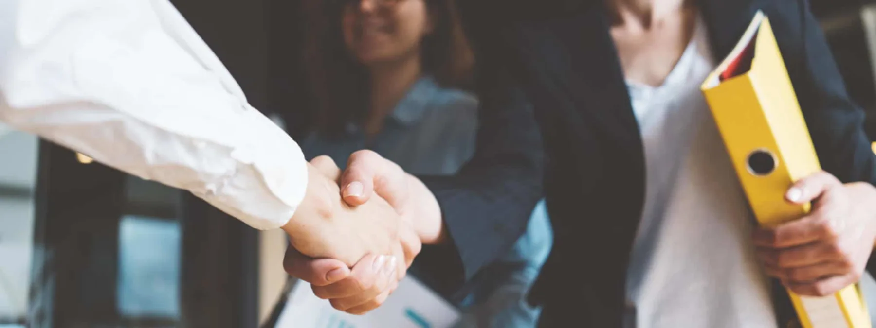 Young business people shaking hands in the office. Successful negotiations. Three persons | Henrika Buchanan Named HNTB’s Transit and Rail Market Sector Leader