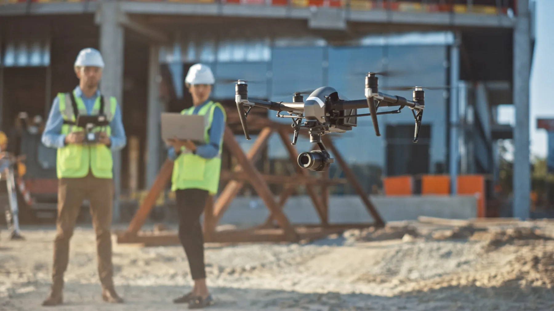 Diverse Team of Specialists Pilot Drone on Construction Site. Architectural Engineer and Safety Engineering Inspector Fly Drone on Commercial Building Construction Site Controlling Design and Quality | ZenaTech Closes Tenth Acquisition of A&J Land Surveyor Inc., Expanding Drone as a Service (DaaS) to Florida’s Aviation, Utility, and Infrastructure Markets