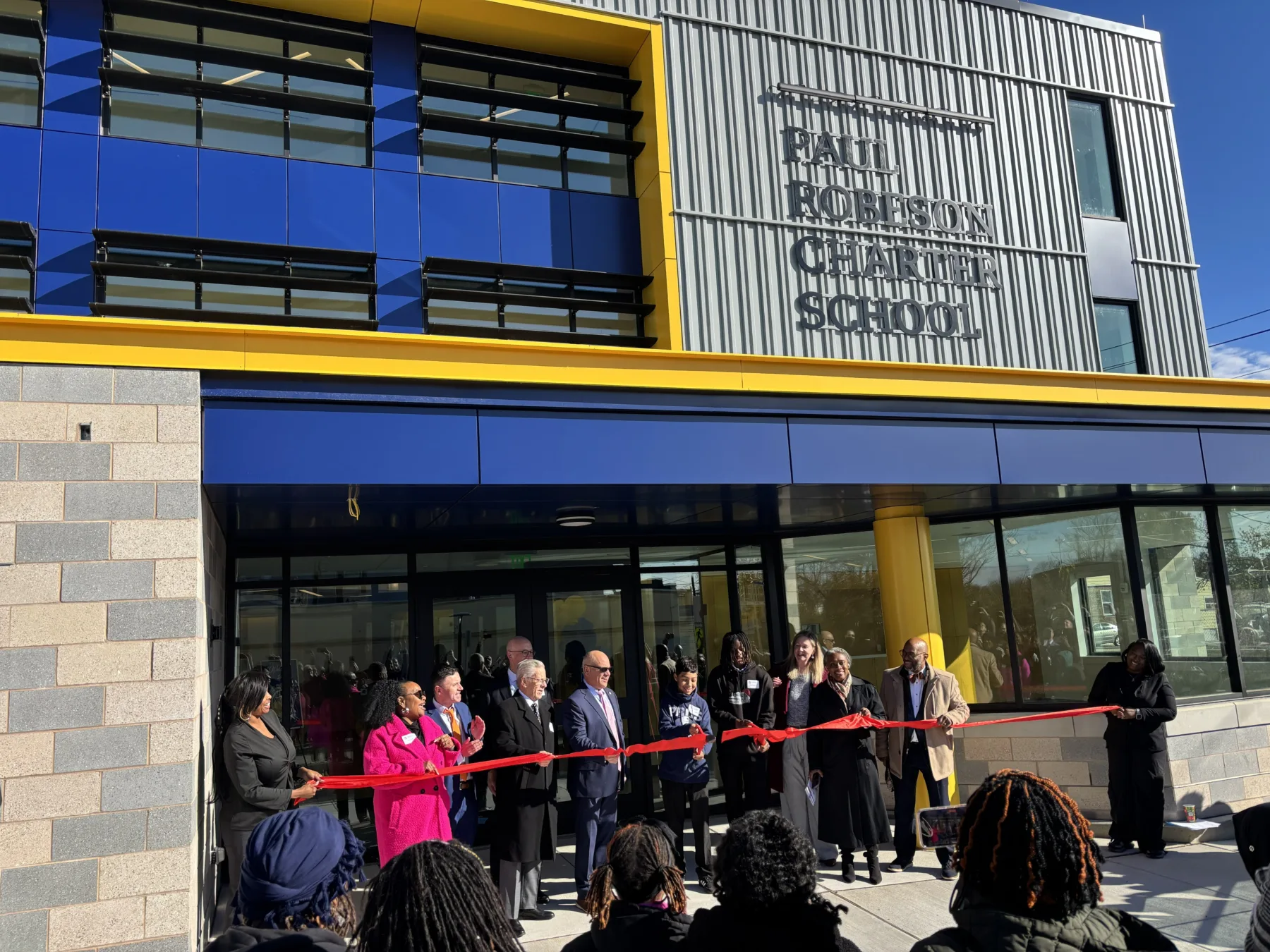 Ribbon cutting ceremony in front of the new Paul Robeson Charter School.