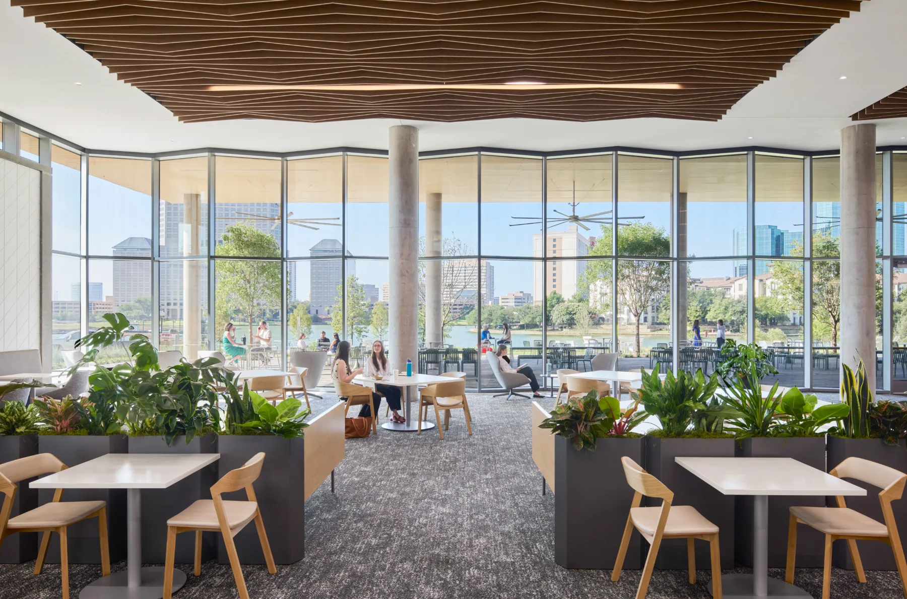 Bright interior dining and meeting space with windows looking out onto the city and water.