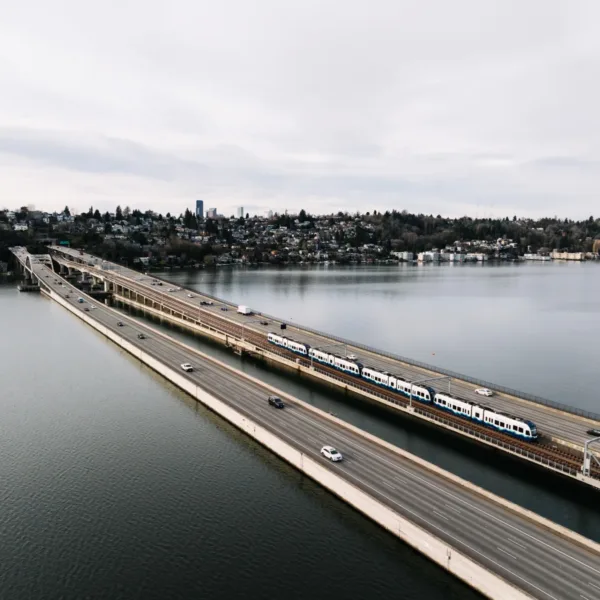 Four-car train sets cross the I-90 floating bridge during pre-revenue operations on January 9, 2026. Photo courtesy of STV. | STV Celebrates World’s First Floating‑Bridge Light Rail with Sound Transit as Crosslake Connection Opens  